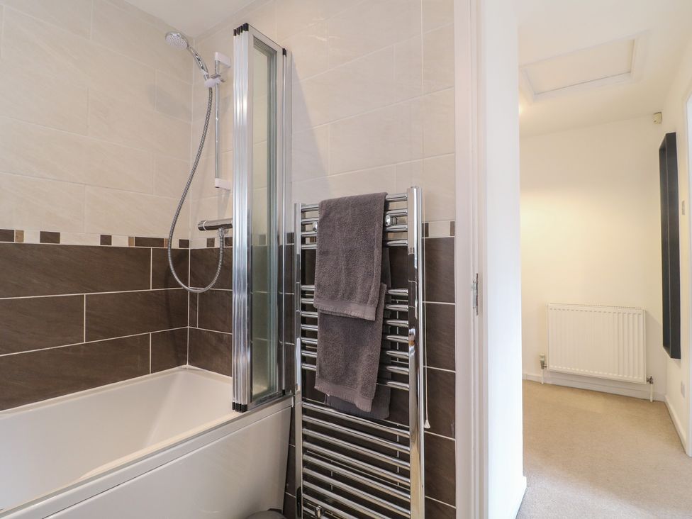 A bathroom featuring a shower over a bathtub and a towel rail at 12 Gorse Lane Syston