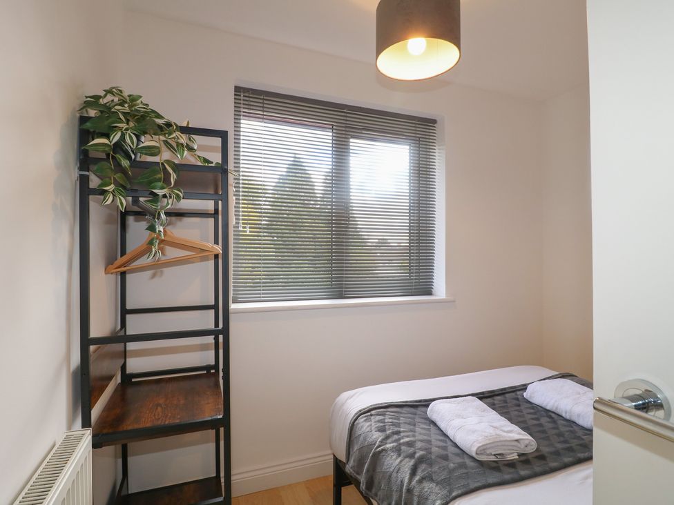 A bedroom with a bed and towels on the bed at 12 Gorse Lane Syston