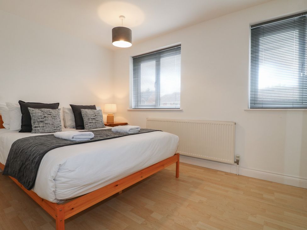 A bedroom with a bed and lamp at 12 Gorse Lane in Syston