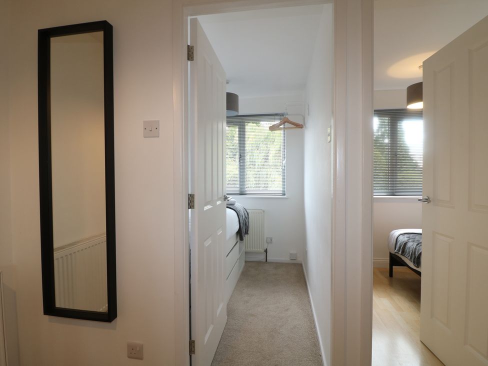 A bedroom with a mirror and a bed at 12 Gorse Lane Syston