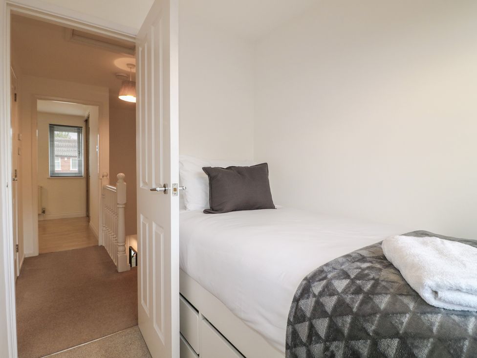 A bedroom with a bed and doorway to the hallway at 12 Gorse Lane Syston