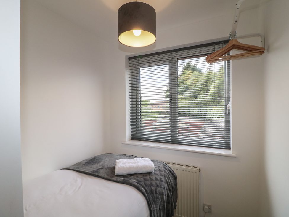 A bedroom with a bed and window at 12 Gorse Lane in Syston