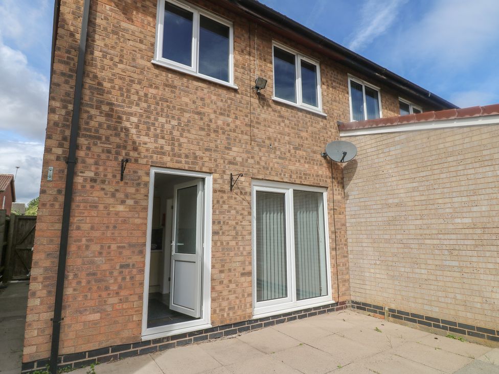 A brick wall house exterior with a door and windows at 12 Gorse Lane Syston