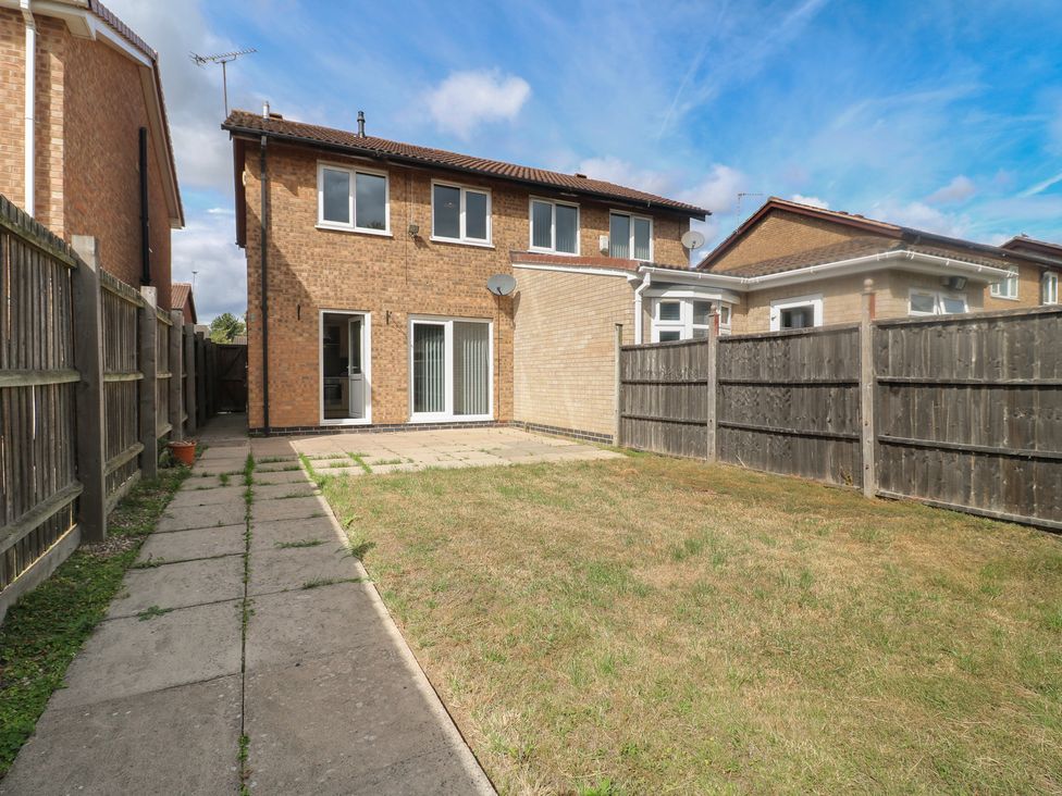 A garden with a house and fence at 12 Gorse Lane Syston