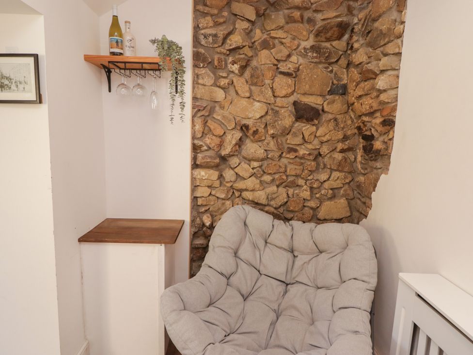 A snug area with a couch and stone wall at 41 St. James Street Narberth