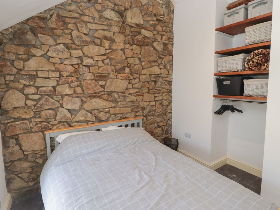 A bedroom with a stone wall and a bed at 41 St. James Street in Narberth