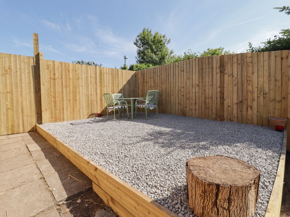 A garden with a table and chairs on gravel at 41 St. James Street in Narberth