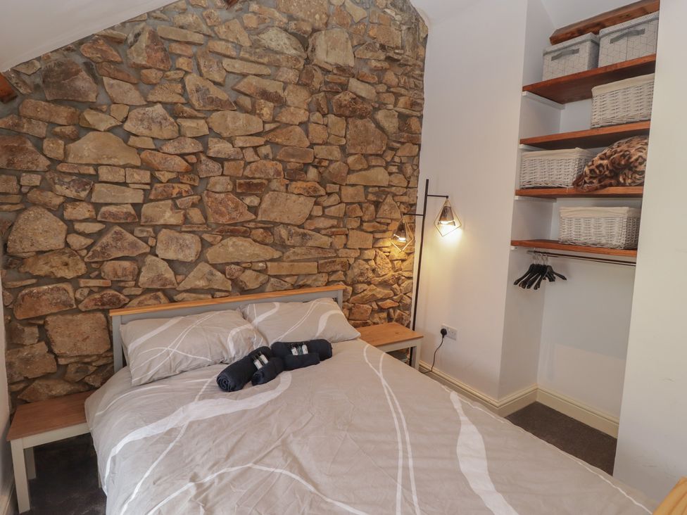 A bedroom with a bed, bedside table and storage at 41 St. James Street in Narberth