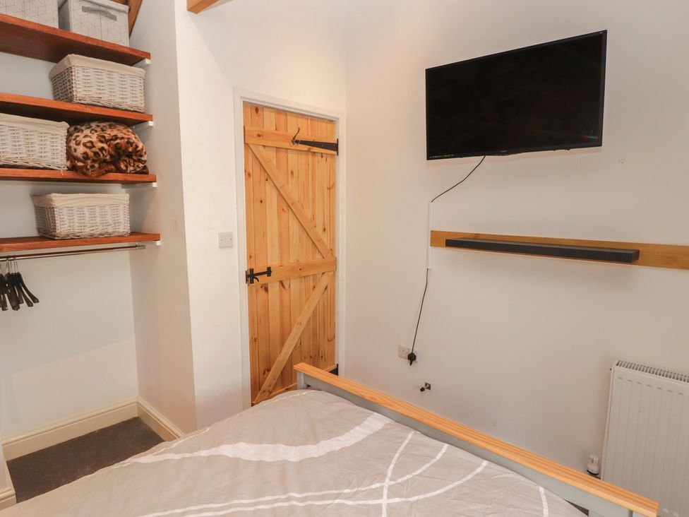 A bedroom with a shelf, basket storage, and a television at 41 St. James Street, Narberth