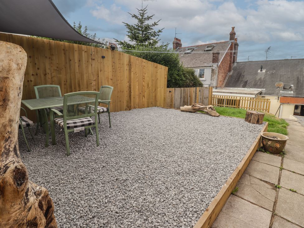 A garden with a table and chairs on gravel at 41 St. James Street Narberth