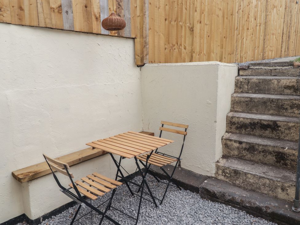 A small outdoor seating area with a table and benches at 41 St. James Street Narberth
