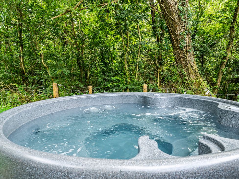 A hot tub filled with water in an outdoor space at Bodior Lodge Rhoscolyn