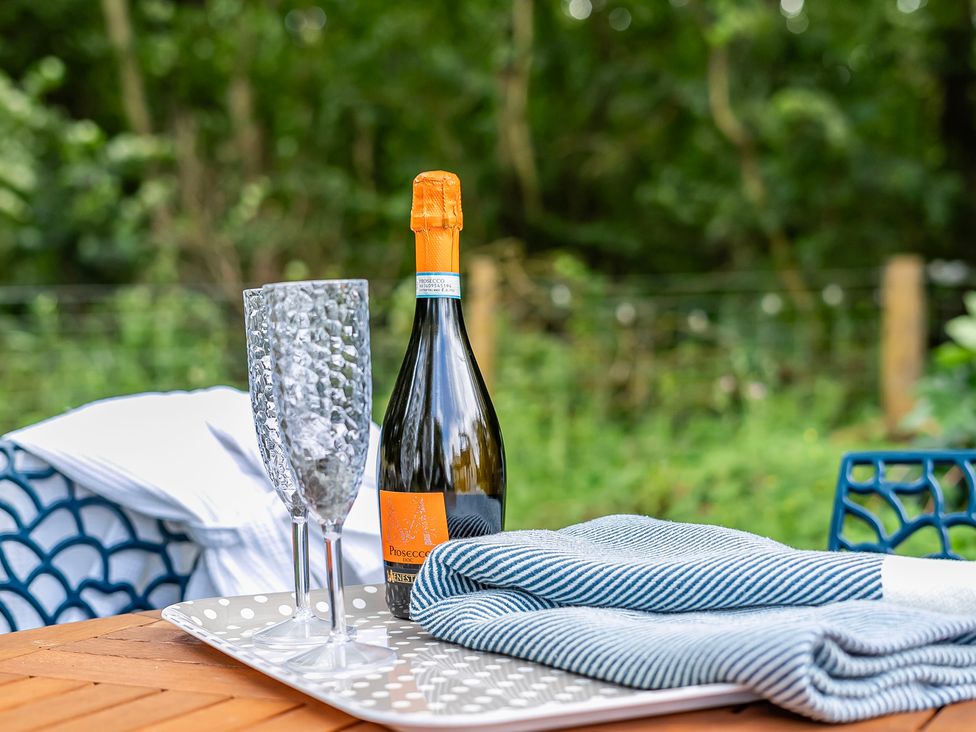 An outdoor setting with prosecco and glasses on a tray at Bodior Lodge in Rhoscolyn