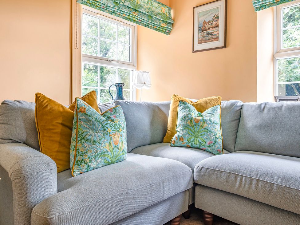 A living room with a sofa and cushions at Bodior Lodge in Rhoscolyn