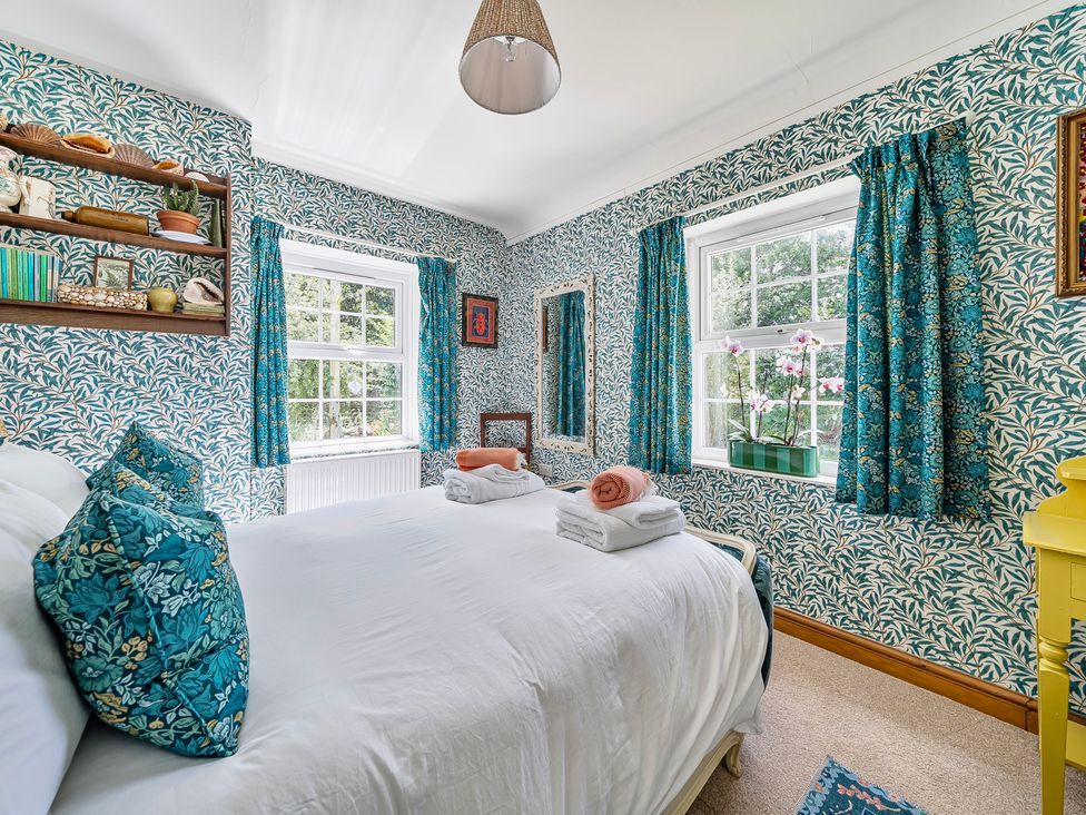 A bedroom with a bed and shelves at Bodior Lodge in Rhoscolyn