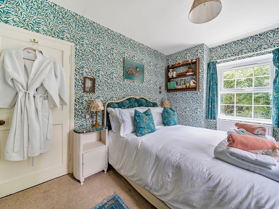 A bedroom with a bed and a shelf at Bodior Lodge Rhoscolyn