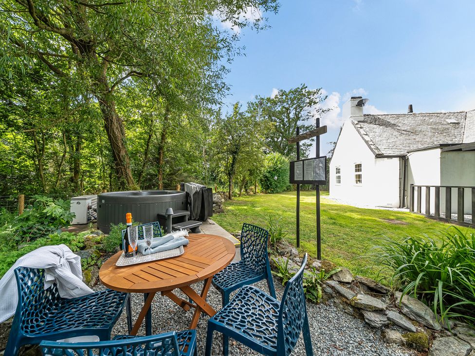A garden with a hot tub and seating area at Bodior Lodge in Rhoscolyn