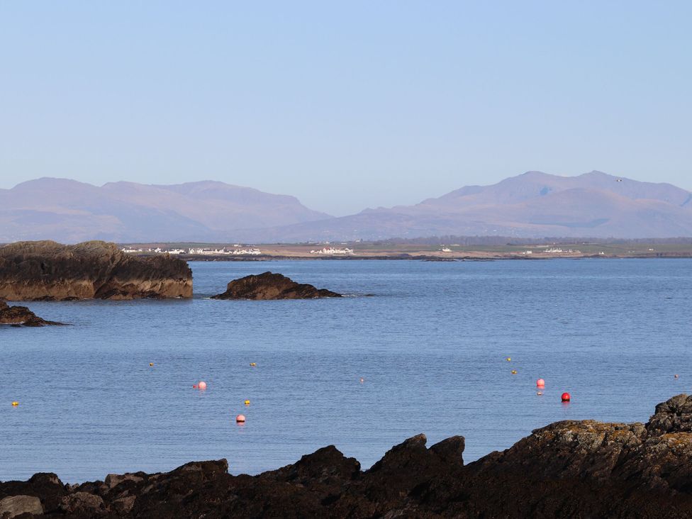 A coastal scene with rocks and water at Bodior Garden Cottage in Rhoscolyn