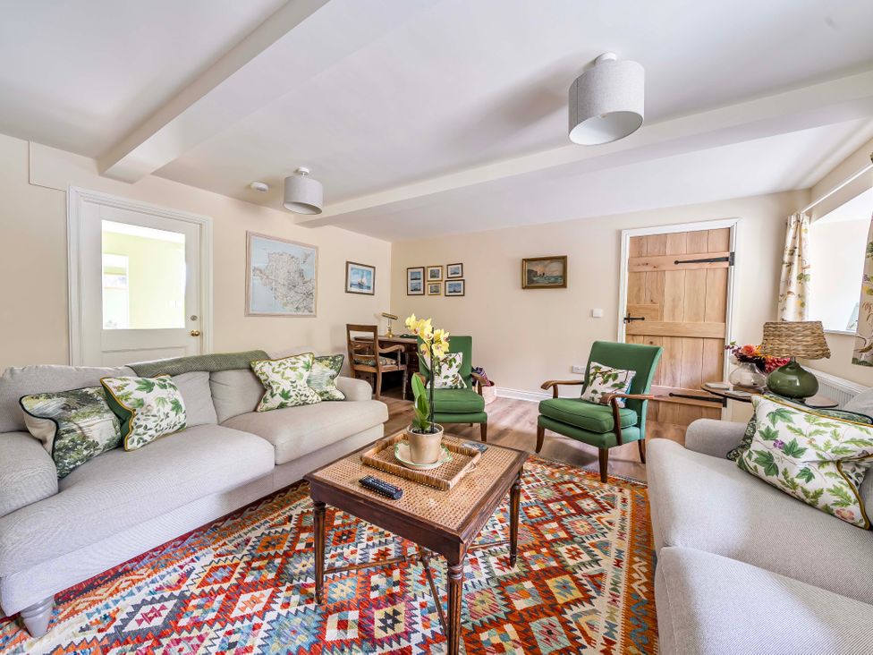 A living room with a sofa and armchairs at Bodior Garden Cottage in Rhoscolyn