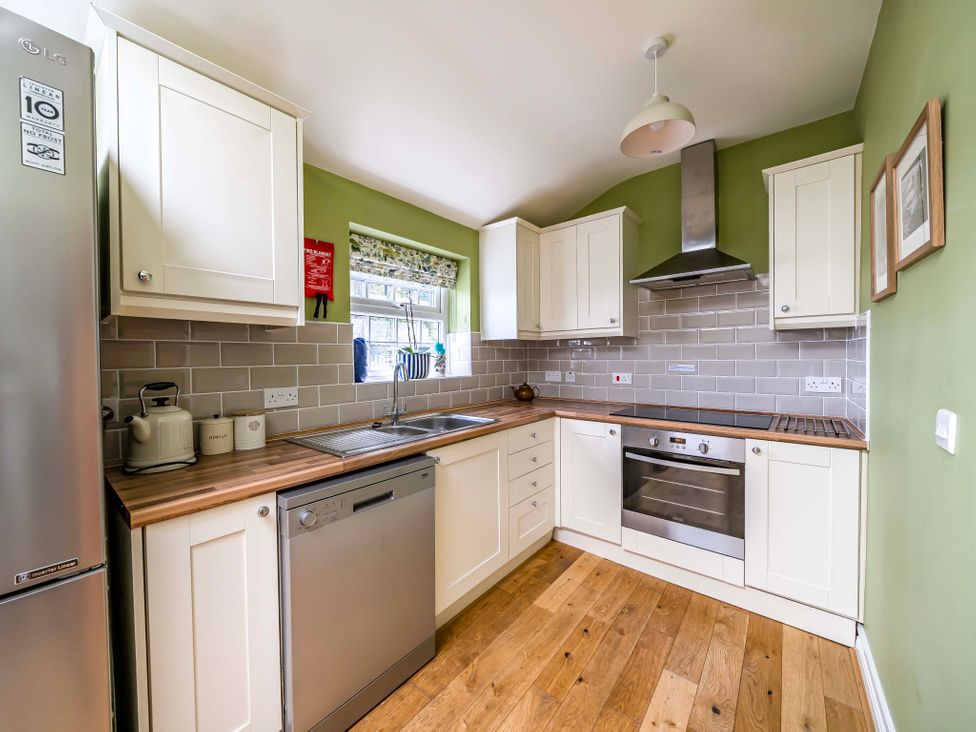 A kitchen with cabinets and appliances at Bodior Garden Cottage in Rhoscolyn