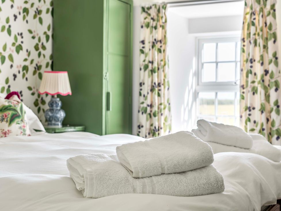 A bedroom with towels on a bed at Bodior Garden Cottage in Rhoscolyn
