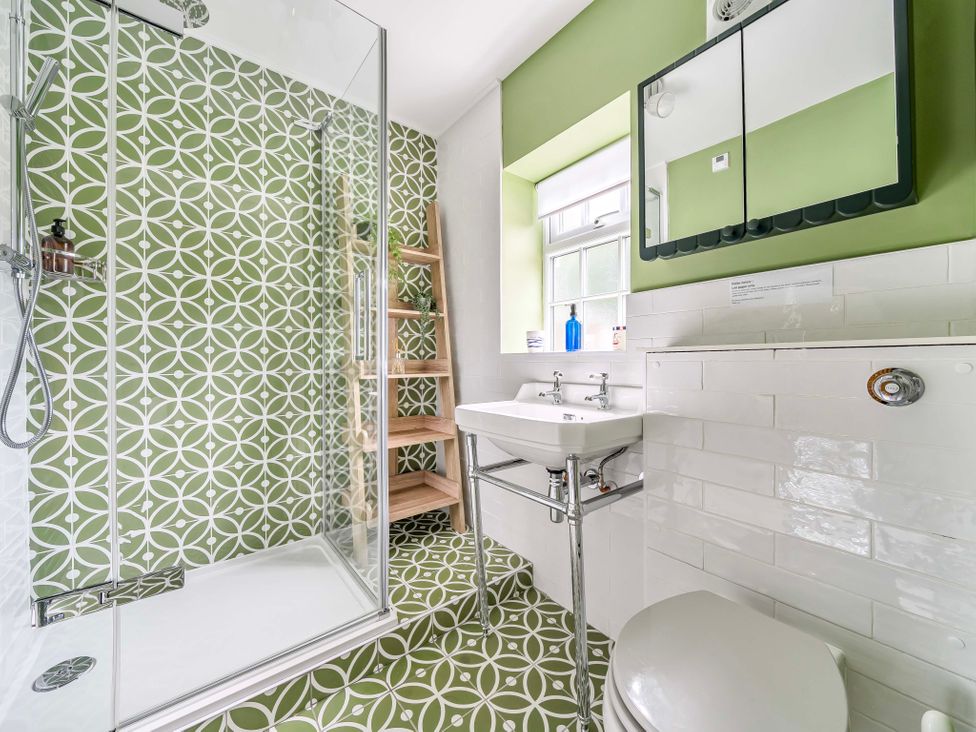 A bathroom with a shower and sink at Bodior Garden Cottage Rhoscolyn