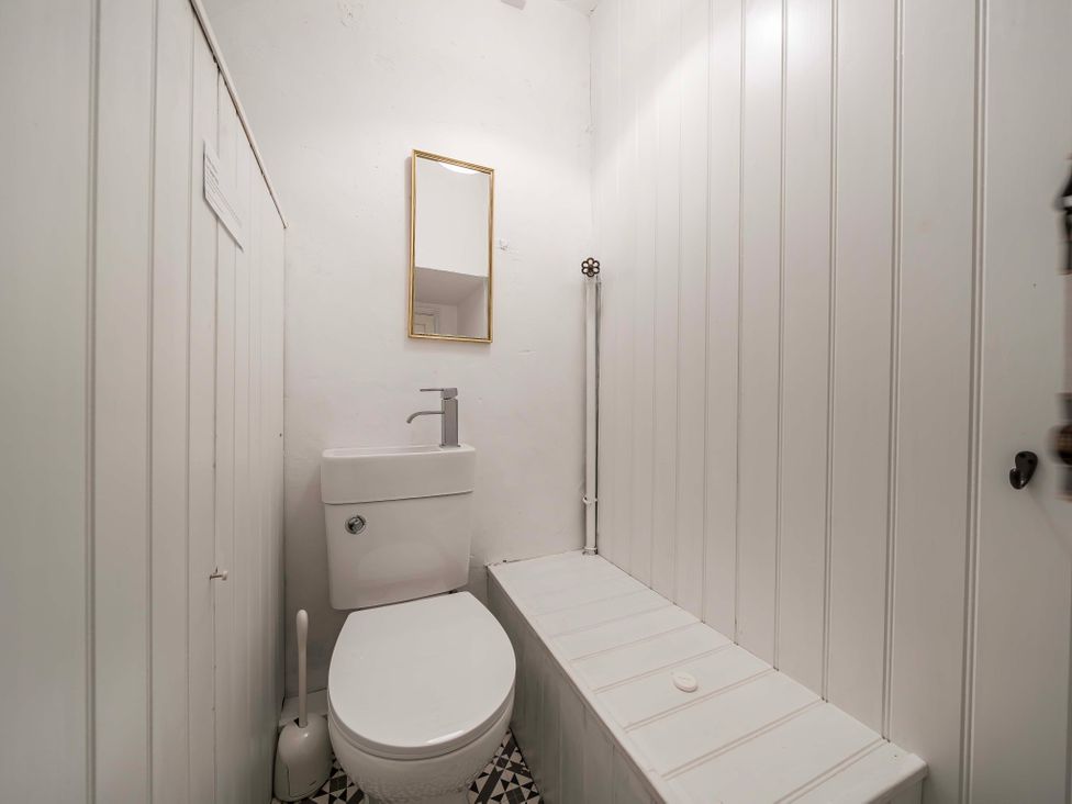 A bathroom with a toilet and sink in Bodior Garden Cottage Rhoscolyn