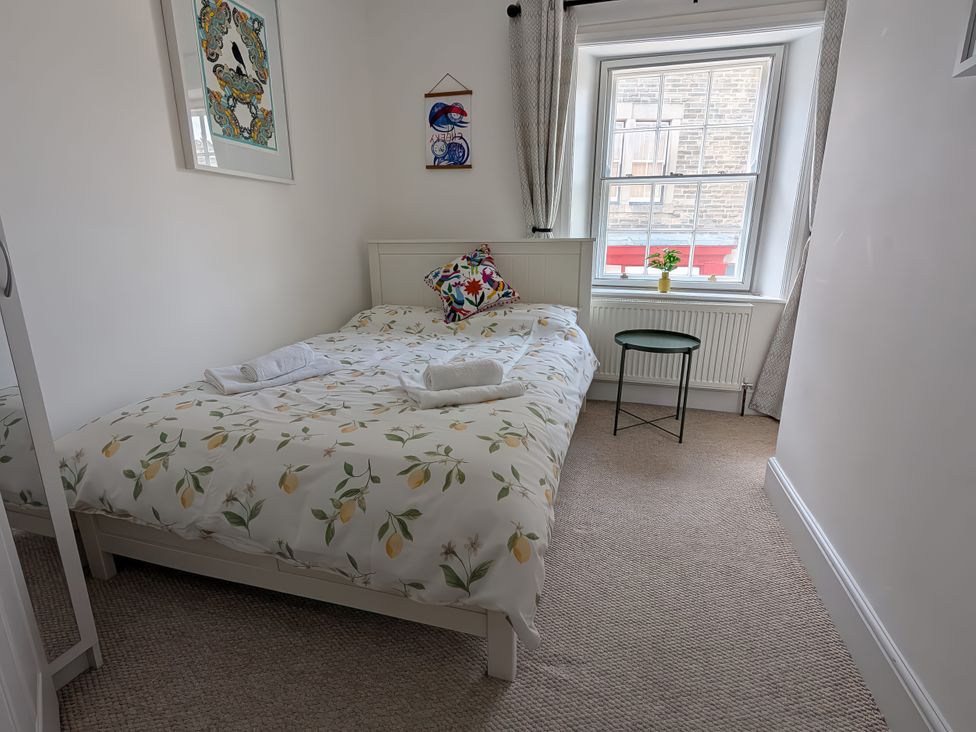 A bedroom with a bed and wall art at 1A Market Street Buxton