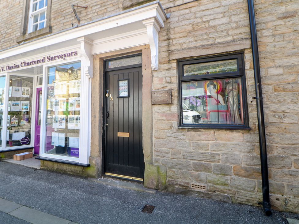 A door and window on a building facade at Cosy Cottage in Buxton