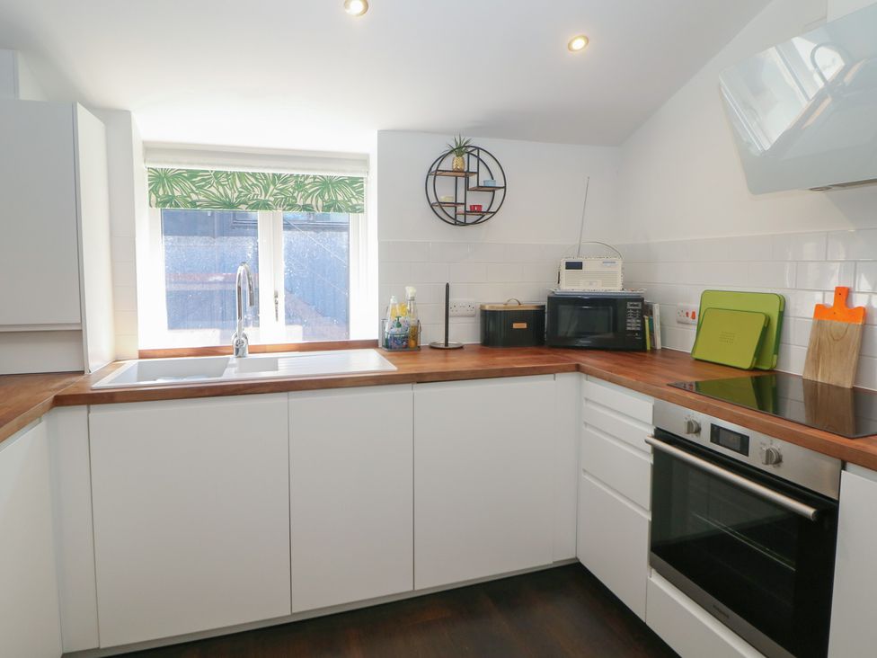 A kitchen with a sink and microwave at Cosy Cottage in Buxton