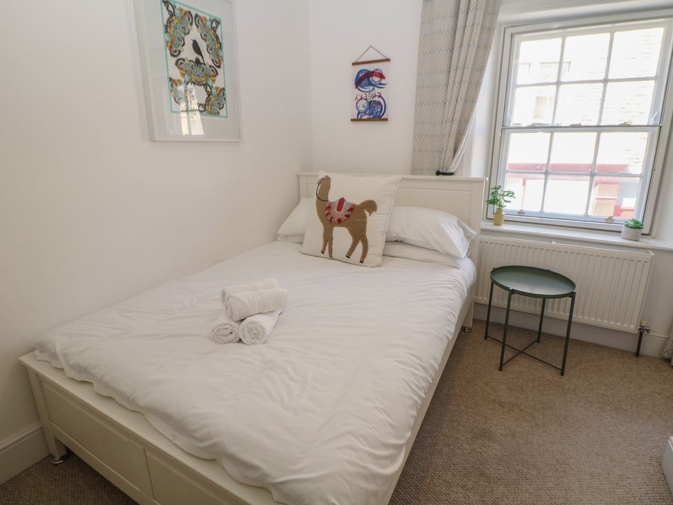 A bedroom with a bed and side table at Cosy Cottage in Buxton