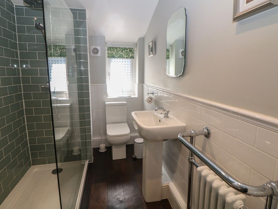 A bathroom with a shower, toilet, and sink at Cosy Cottage in Buxton