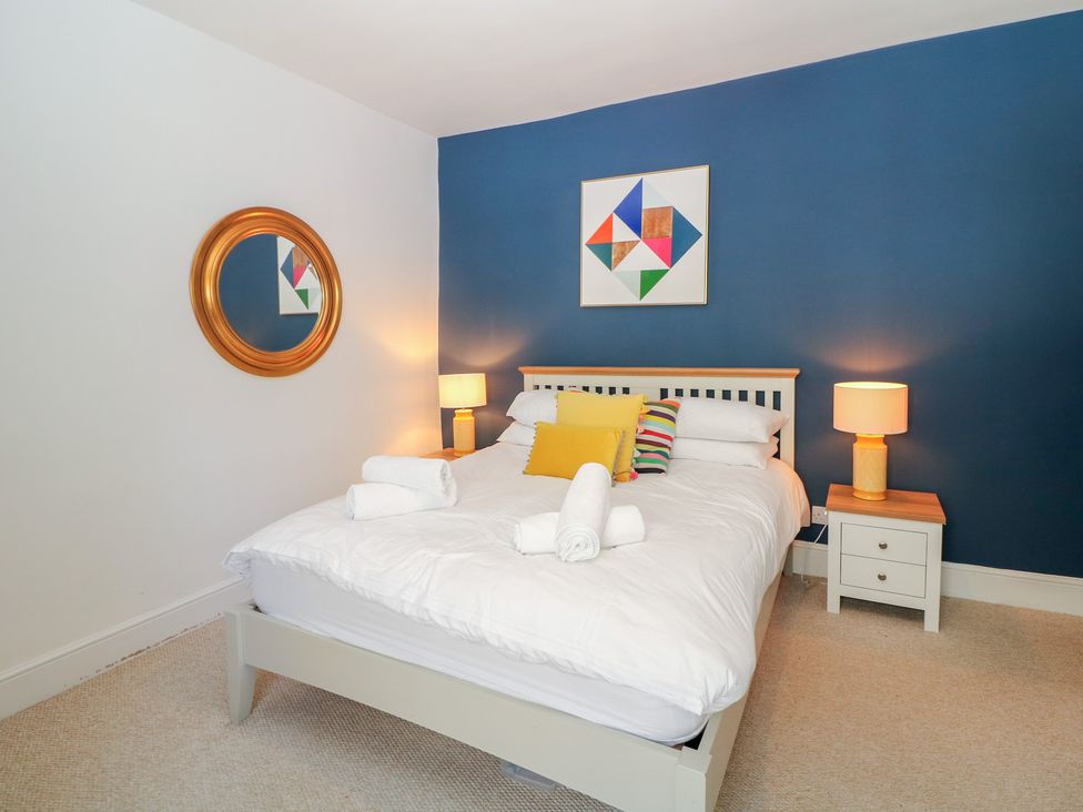 A bedroom with a bed and nightstand at Cosy Cottage in Buxton