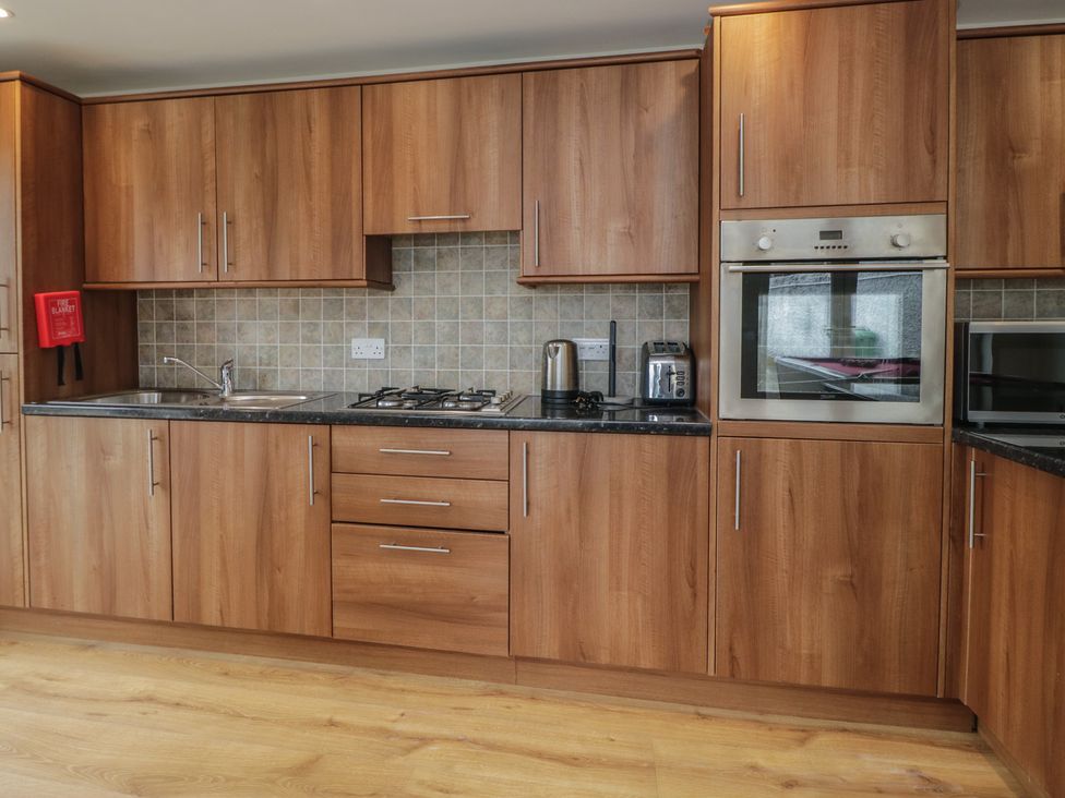 A kitchen with wooden cabinetry and appliances at Whimhowe in Windermere