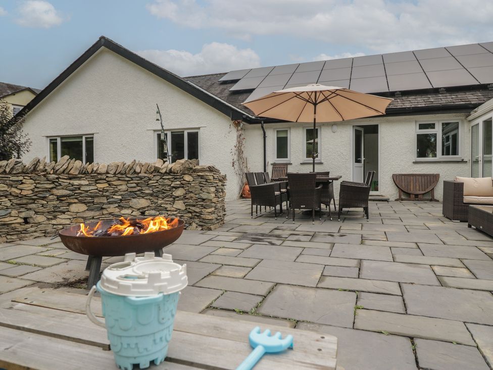A patio with fire pit and seating area at Whimhowe in Windermere