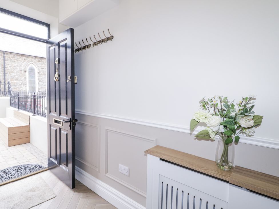 A hallway with a door and coat hooks at 41 Church view Portstewart