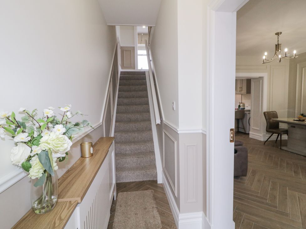 A hallway with a staircase and a table at 41 Church view Portstewart