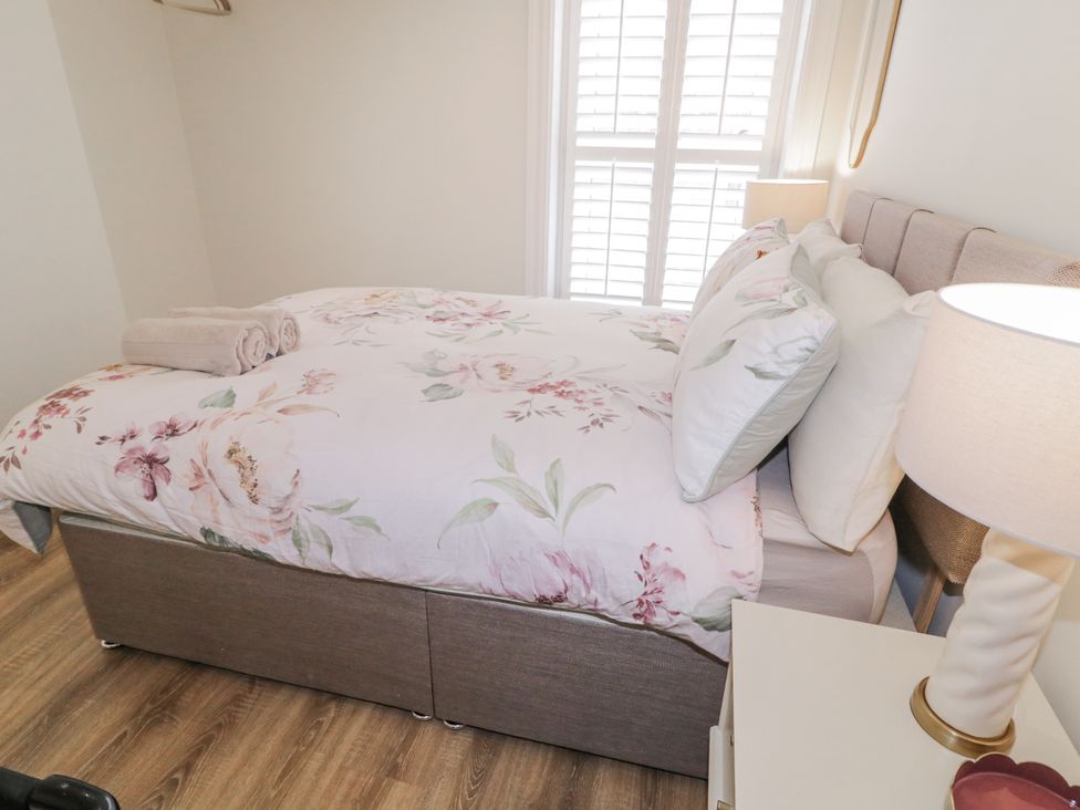 A bedroom with a bed, pillows, towels, and a lamp at 41 Church view in Portstewart