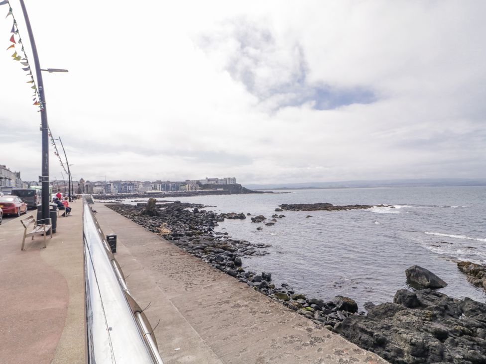 A view of the coast with a sidewalk and buildings at 41 Church view Portstewart