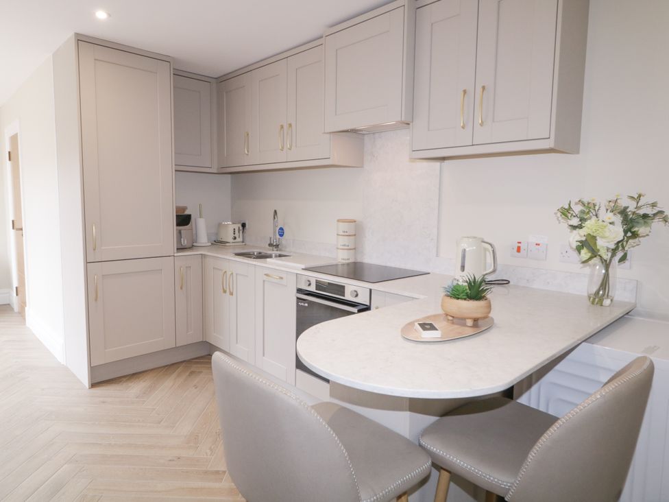 A kitchen with cabinets, stove, sink, and bar stool at 41 Church view, Portstewart, County Londonderry