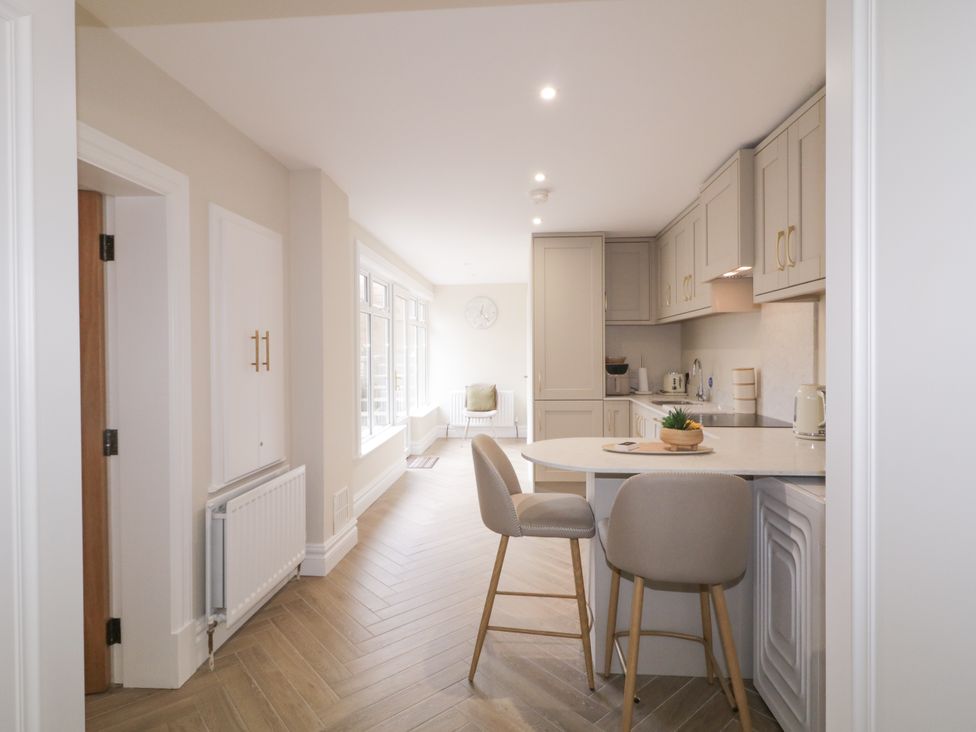 A kitchen with bar stools and cabinets at 41 Church view, Portstewart, County Londonderry