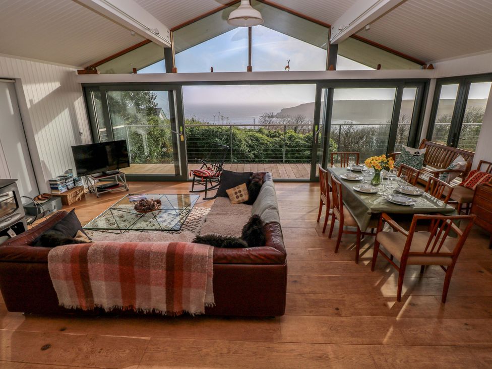 A living room with a sofa and dining table at Green Shutters in Freshwater East near Lamphey