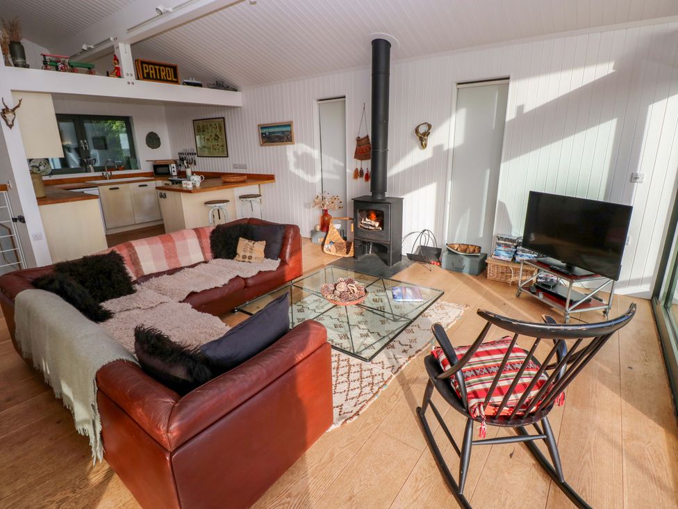 A living room with a fireplace and coffee table at Green Shutters in Freshwater East near Lamphey