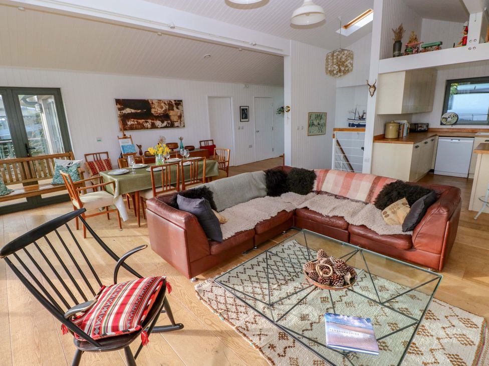 A living room with a sectional sofa and dining area at Green Shutters Freshwater East near Lamphey