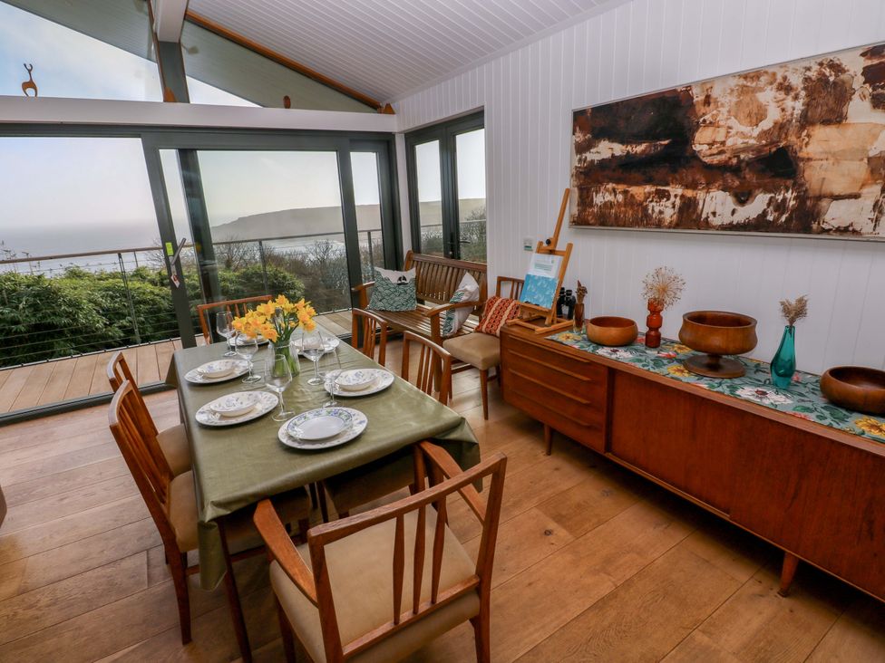 A dining room with a table set for a meal at Green Shutters Freshwater East near Lamphey