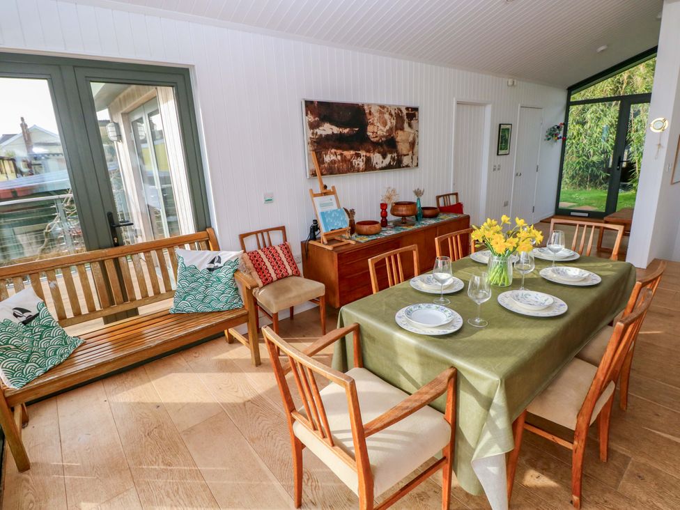A dining room with a table set for a meal at Green Shutters in Freshwater East near Lamphey