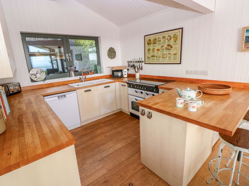 A kitchen with a sink and stove at Green Shutters in Freshwater East near Lamphey