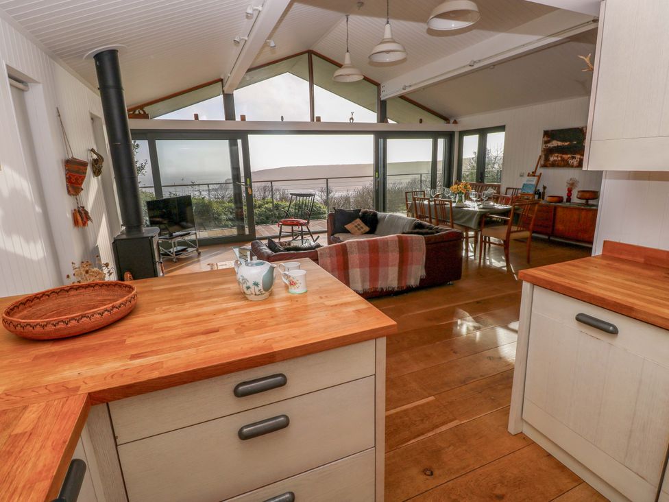 A kitchen with a view of the living area at Green Shutters Freshwater East near Lamphey