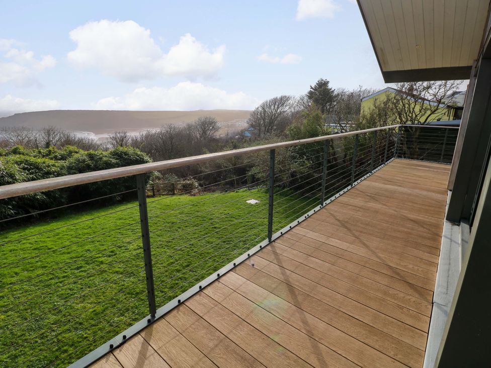 A deck with railing and a view of grass and landscape at Green Shutters in Freshwater East near Lamphey
