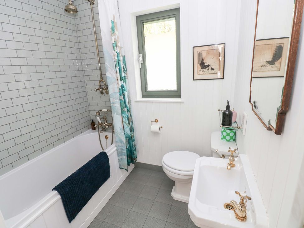 A bathroom featuring a bathtub, toilet, and sink at Green Shutters in Freshwater East near Lamphey